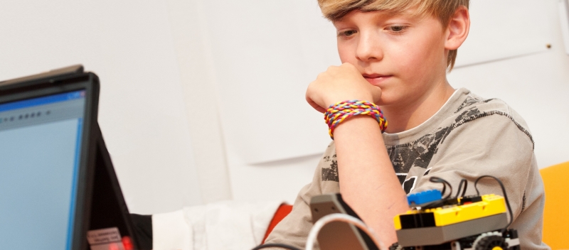 Beim Programmieren weiß man nie im Voraus, wie lange es dauert. Ein Junge brütet über einem Problem zur Robotik